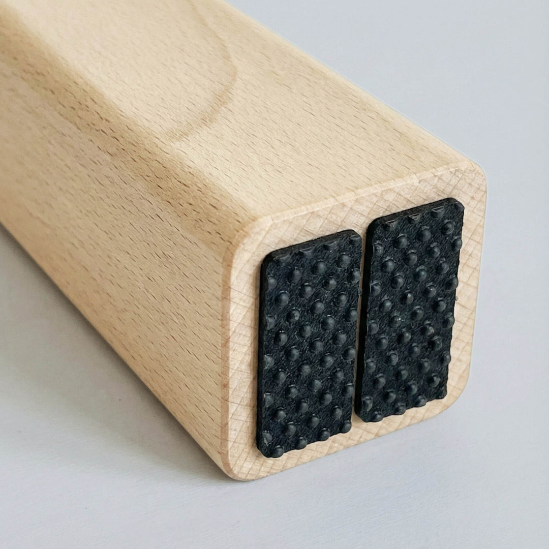 Close-up of non-slip rubber pads under the H-Tree feet for stable grip and floor protection.